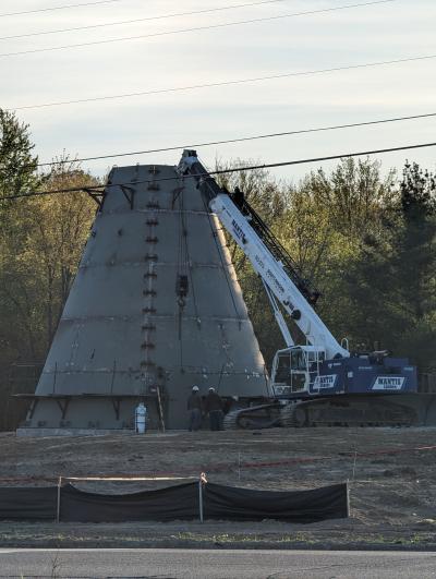 Picture is of the base of the water tower being built on the northeast corner of the Fenton Road and Thompson Road intersection. There is a crane next to the water tower base. The water tower is projected to be completed during the summer of 2024. 